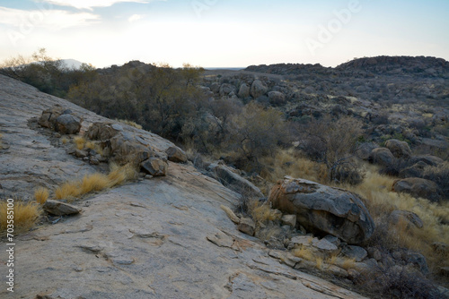 Large boulders are scattered on the evening rocky slopes. Natural landscape reserve