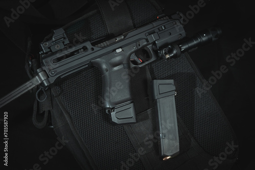 Tactical pistol with a stock and a flashlight, close-up photo on a black background.