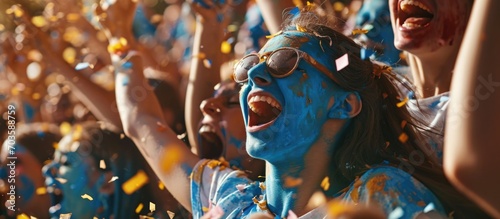 Sports stadium event: Fans cheer for the blue soccer team, celebrate goal and championship victory. Friends with painted faces have emotional fun.