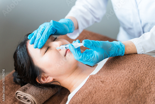 クマ治療・顔にヒアルロン酸・脂肪注入注射を打つ患者と美容外科の医師
 photo