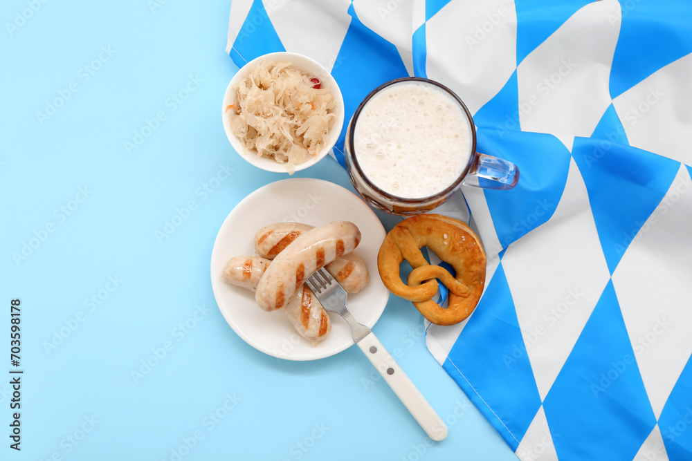 Tasty sausages, sauerkraut, flag of Bavaria, pretzel and mug with beer on blue background. Oktoberfest celebration Tasty sausages, sauerkraut, flag of Bavaria, pretzel and mug with beer on blue background. Oktoberfest celebration