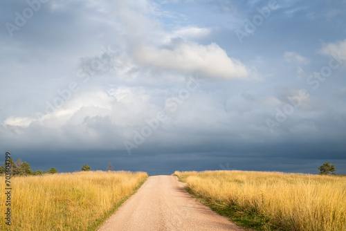 dirt road in Nebraska prairie with dark stormy sky photo