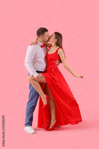 Lovely couple kissing on pink background. Valentine s Day celebration