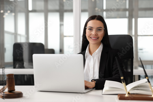 Smiling lawyer working on laptop in office