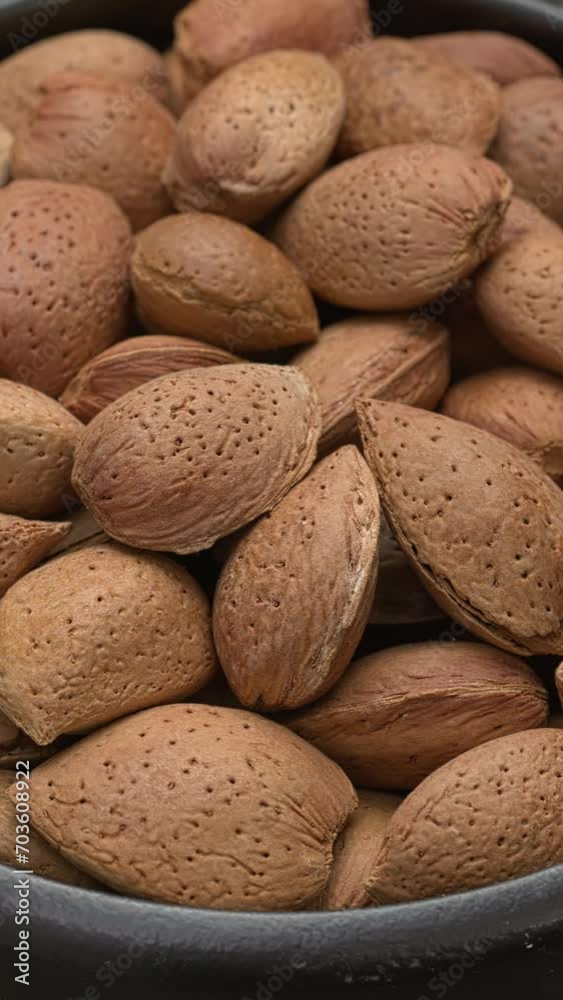 Unshelled almonds in bowl. Table spin. Vertical video. Unshelled almonds in bowl. Table spin. Vertical video.