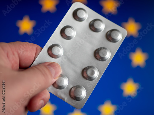 Silver Pill Package in Hand Before European Union Flag photo