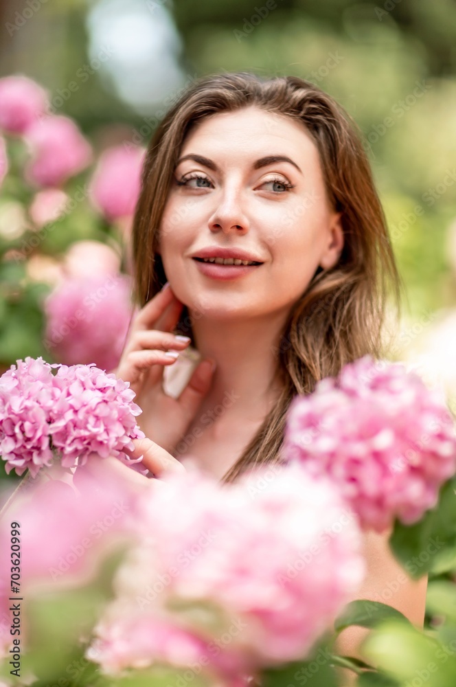 Hydrangeas Happy woman in pink dress amid hydrangeas. Large pink hydrangea caps surround woman. Sunny outdoor setting. Showcasing happy woman amid hydrangea bloom. Hydrangeas Happy woman in pink dress amid hydrangeas. Large pink hydrangea caps surround woman. Sunny outdoor setting. Showcasing happy woman amid hydrangea bloom.