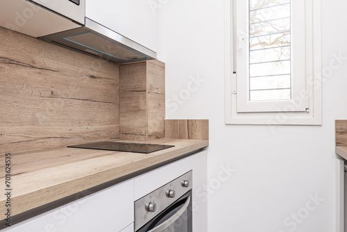 Corner of a small kitchen with white furniture