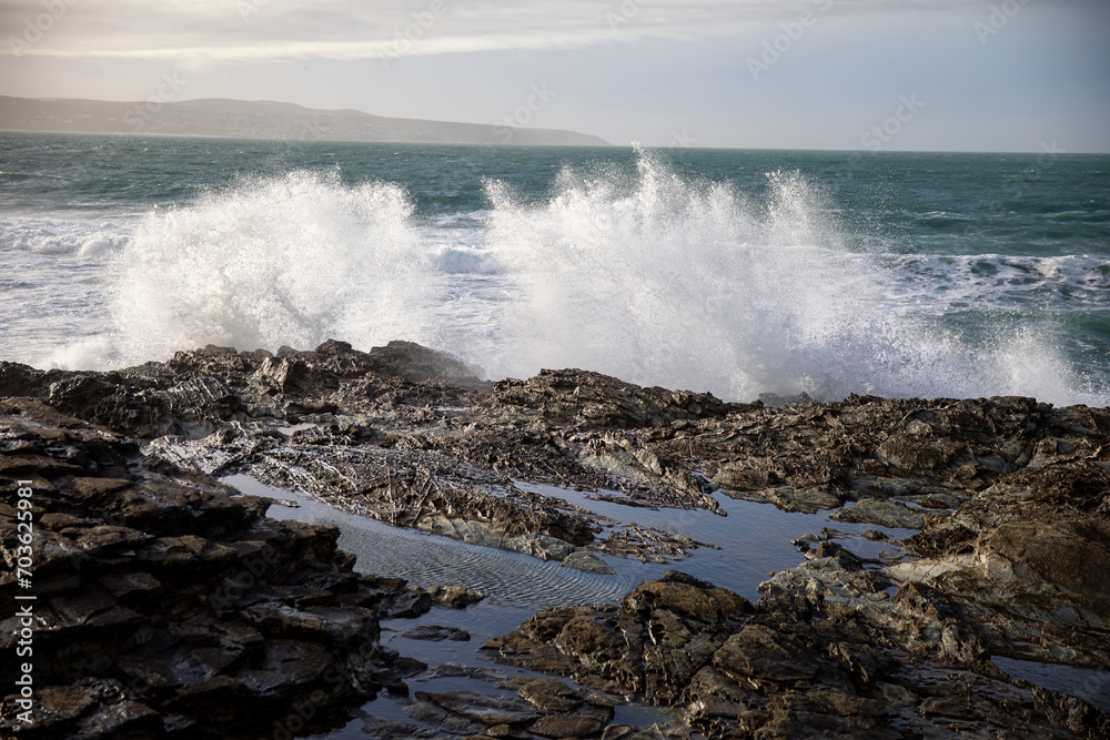 Waves crashing on the rocky shore at Godrevy Beach in the UK.