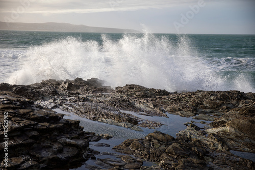 Waves crashing on the rocky shore at Godrevy Beach in the UK.