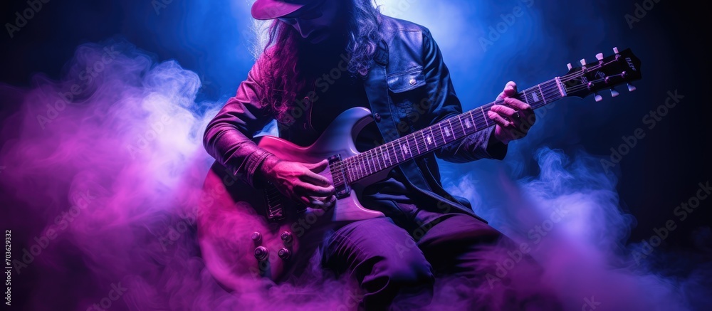 musician playing guitar with purple flare. dark background