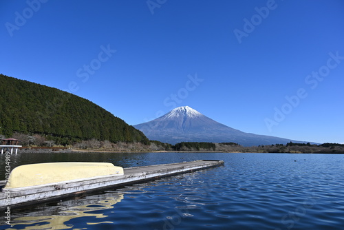 静岡県の朝霧高原に田貫湖の桟橋に置いてある船と冬景色の富士山の眺め