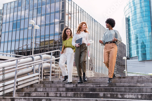 Confident businesspersons talking in front of modern office building. Businesswoman have business conversation. Banking and financial market concept