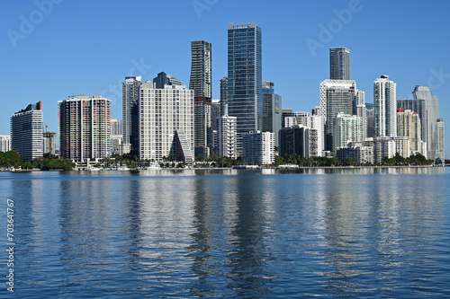 City of Miami  Florida skyline reflected in calm water of Biscayne Bay on calm cloudless December morning.