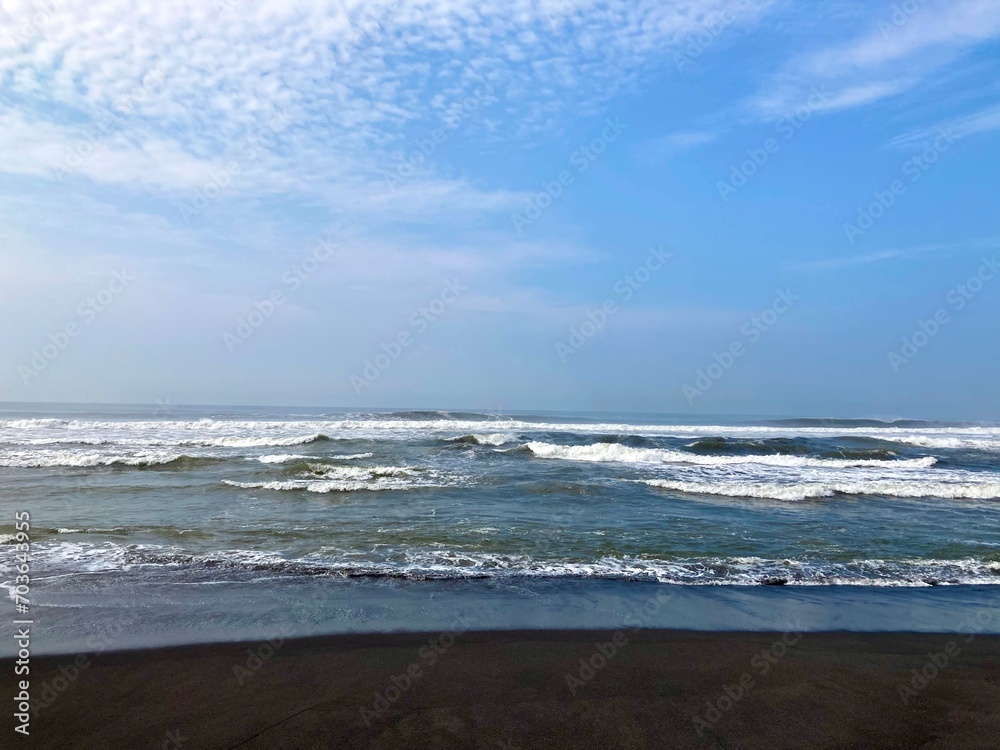 sea waves on a beach with black sand, holiday and vacation at summer