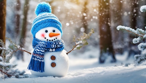 Cute snowman in a blue knitted bobble hat and scarf in a winter forest with copy space. photo