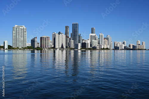 City of Miami, Florida skyline reflected in calm water of Biscayne Bay on calm cloudless December morning.