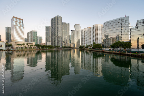 City of Miami, Florida skyline reflected in calm water of Biscayne Bay at sunrise on clear cloudless December morning.