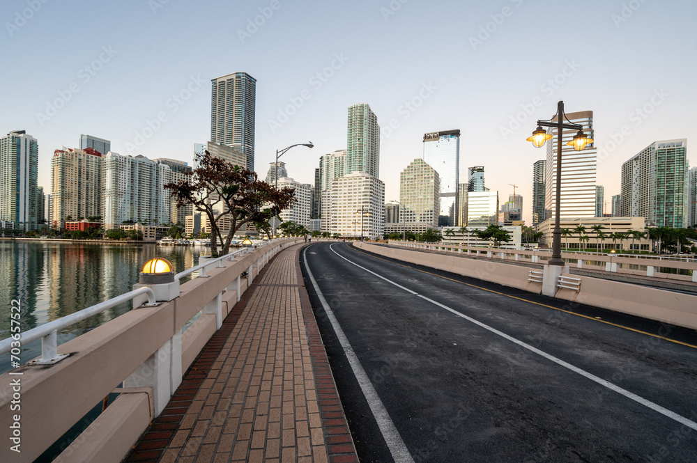 Brickell Key Bridge and City of Miami skyline at sunrise under clear blue sky on tranquil December morning. Brickell Key Bridge and City of Miami skyline at sunrise under clear blue sky on tranquil December morning.