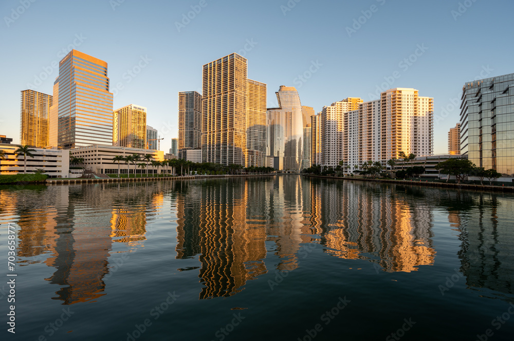 Fototapeta premium City of Miami, Florida skyline reflected in calm water of Biscayne Bay at sunrise on clear cloudless December morning.