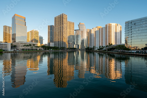 City of Miami  Florida skyline reflected in calm water of Biscayne Bay at sunrise on clear cloudless December morning.