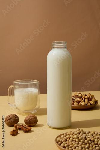 Wooden dishes of soybeans  cashew nuts and walnuts displayed on beige surface with containers of milk. Nuts are a great source of several nutrients  including vitamin E