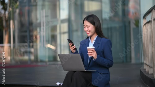 Young Asian business woman leader entrepreneur, professional manager holding digital tablet computer uon the street in big city photo