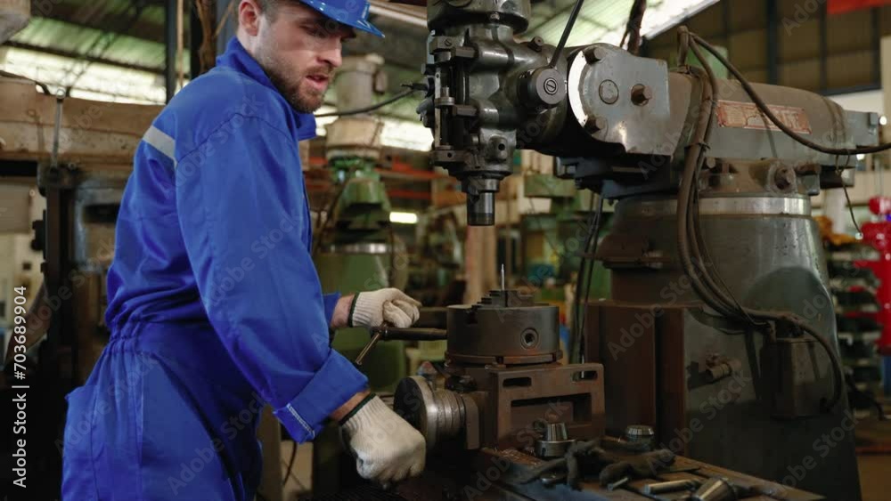 technician looks down at a workpiece inside a metal lathe shop.
technician looks down at a workpiece inside a metal lathe shop.