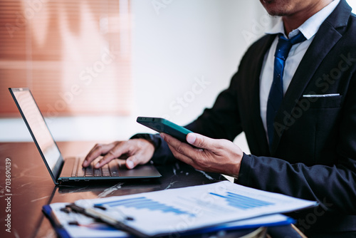Businessman working at office with laptop and documents on his desk, modern work concep