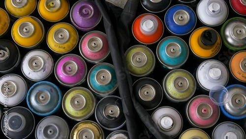Graffiti spray cans in various colors, top down footage