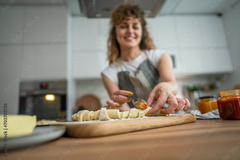 Woman caucasian female prepare breakfast croissants dough at kitchen