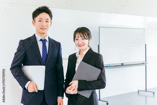 会議室・オフィスにいる若い日本人ビジネスマンとビジネスウーマン 