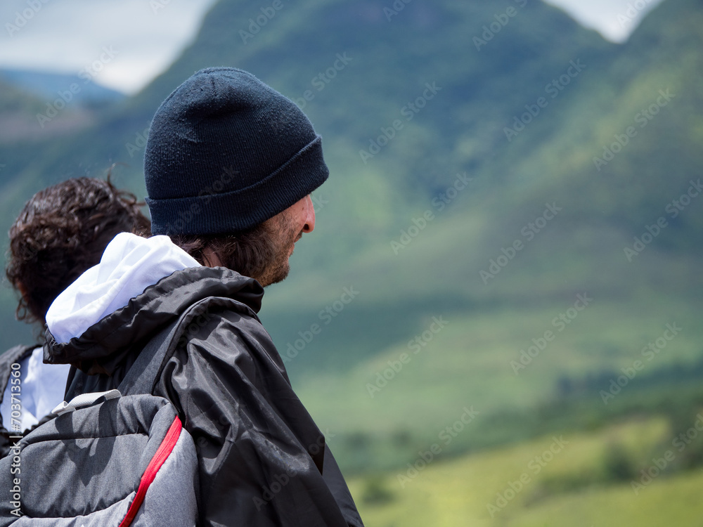 Couple de voyageurs observant une chaîne de montagnes vertes