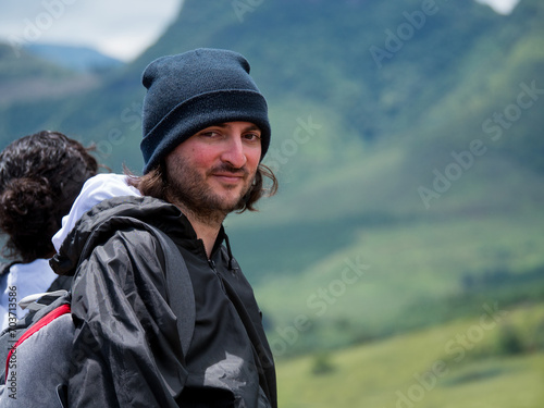 Un randonneur souriant et heureux du magnifique paysage de montagne vertes 