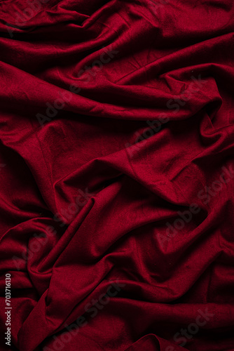 Closeup of rippled red satin fabric as background texture
