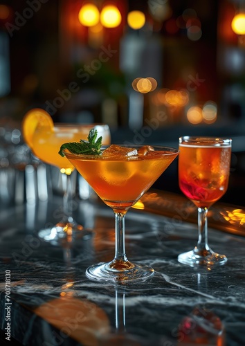 cocktails on marble bar top in night club setting, the cocktail are orange colour