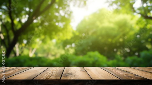 Wood table top on blur green background of trees in park on sunny day