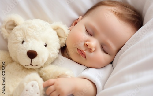 Carefree sleep little baby with a soft toy on the bed.