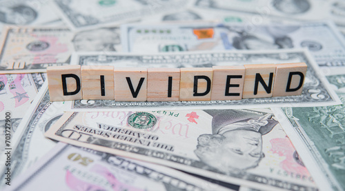 The inscription dividend on the background of American dollars. Investing in Dividend Aristocrats