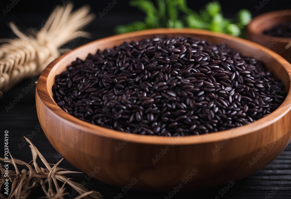 Black rice in wooden bowl on a dark table Black rice in wooden bowl on a dark table