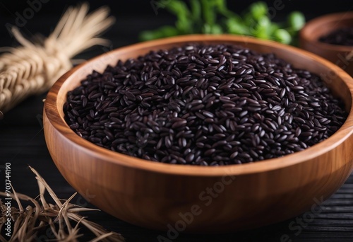 Black rice in wooden bowl on a dark table
