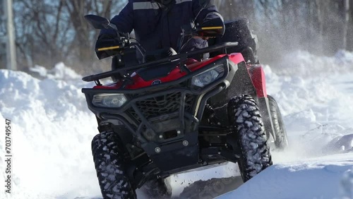 The ATV rides in slow motion through the snow