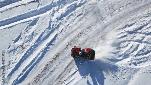 Top view of ATV riding in snowy field. Aerial shot