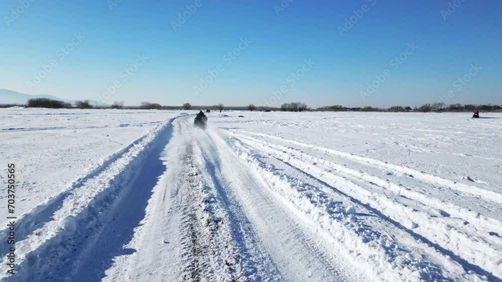 Top view of ATV riding in snowy field. Aerial shot Top view of ATV riding in snowy field. Aerial shot