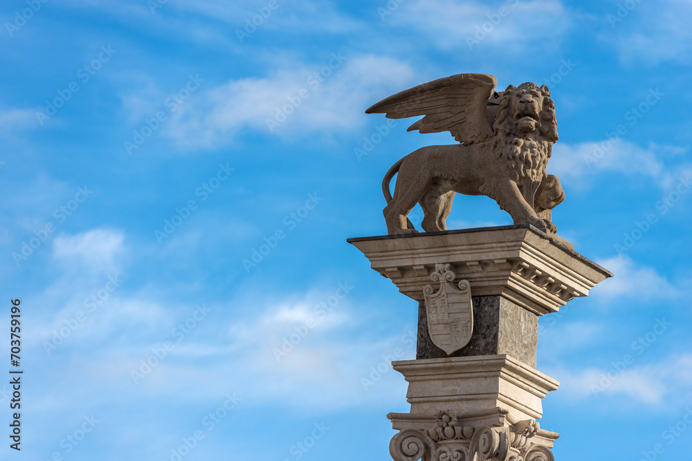 Statue of the Winged Lion of Saint Mark, symbol of the evangelist, the Venetian Republic and the Veneto Region. Freedom square (Piazza della Libertà), Udine, Friuli-Venezia Giulia, Italy, Europe.