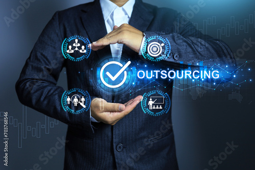Outsourcing manpower concept with businessman holding checkmark to approved hiring outsource employee or partnership worker to be a staff in company with contract periods photo