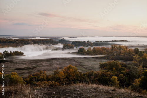 Fototapeta Naklejka Na Ścianę i Meble -  autumn dawn, fog in the field above the trees