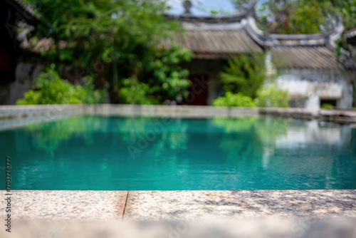 Obraz na plátně Tranquil Poolside Oasis - The calm waters of a secluded pool reflect the lush greenery of a traditional courtyard setting