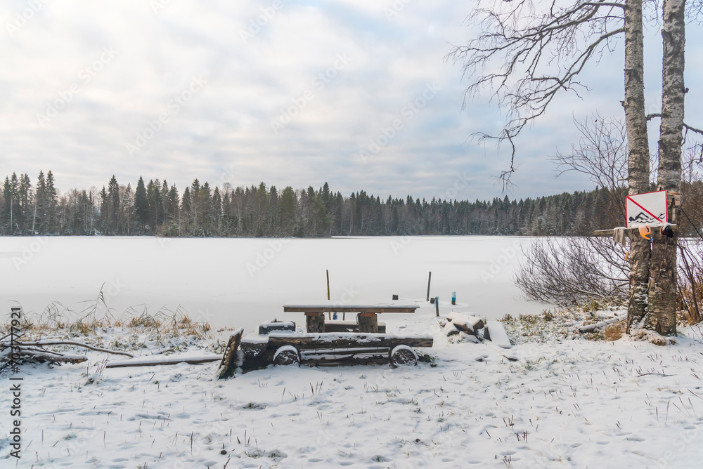 frozen forest lake with a picnic spot in the snow frozen forest lake with a picnic spot in the snow