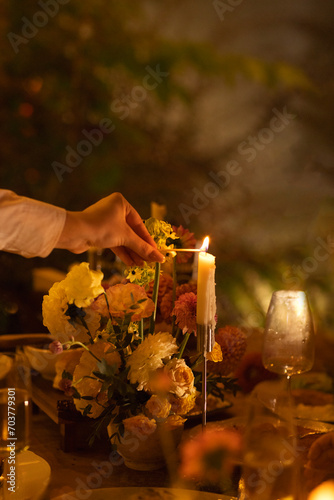 Wedding table for guests, decorated with candles, are served with cutlery and crockery and covered with yellow tablecloth